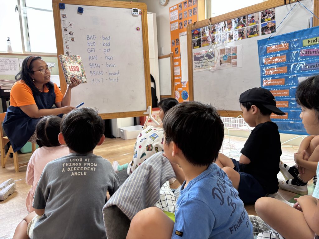 英語イマージョン環境で教師の話を聞きながら学ぶ子どもたち（名古屋市名東区）